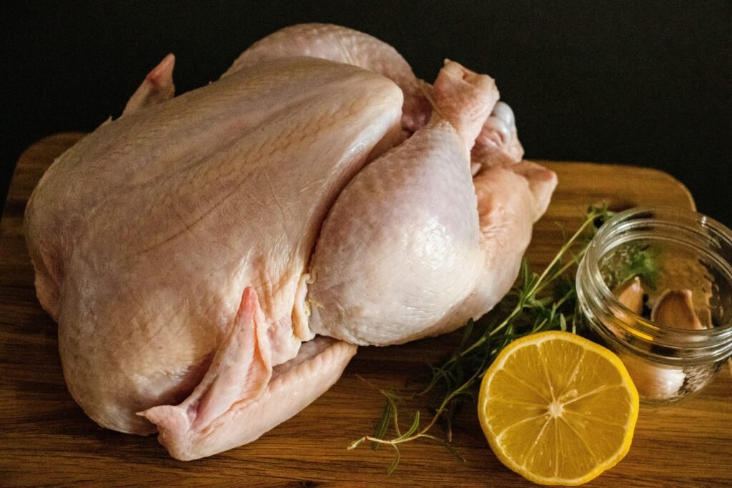 raw chicken meat on brown wooden chopping board raw chicken meat on brown wooden chopping board