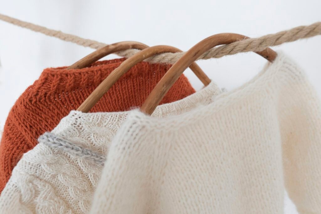 a couple of sweaters hanging on a clothes line a couple of sweaters hanging on a clothes line