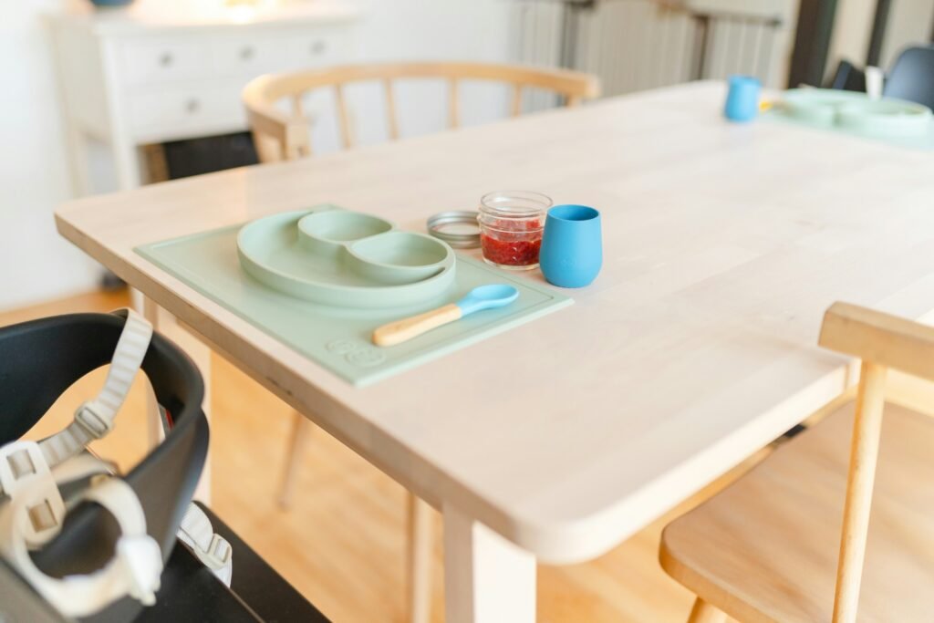 a table with a bowl, plate, and spoon on it a table with a bowl, plate, and spoon on it