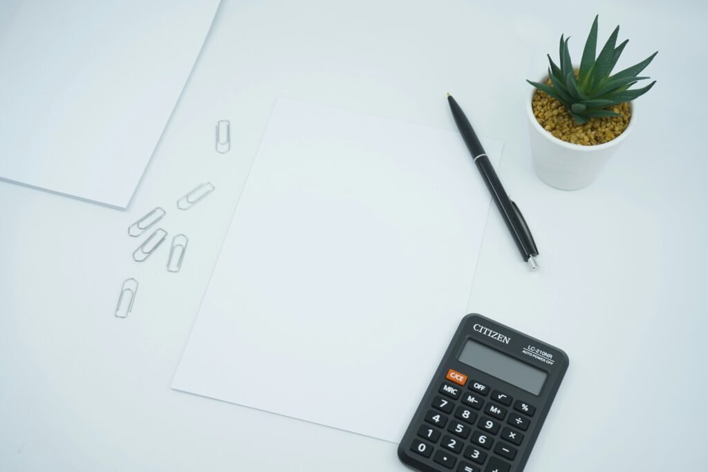 black calculator beside black pen on white printer paper black calculator beside black pen on white printer paper