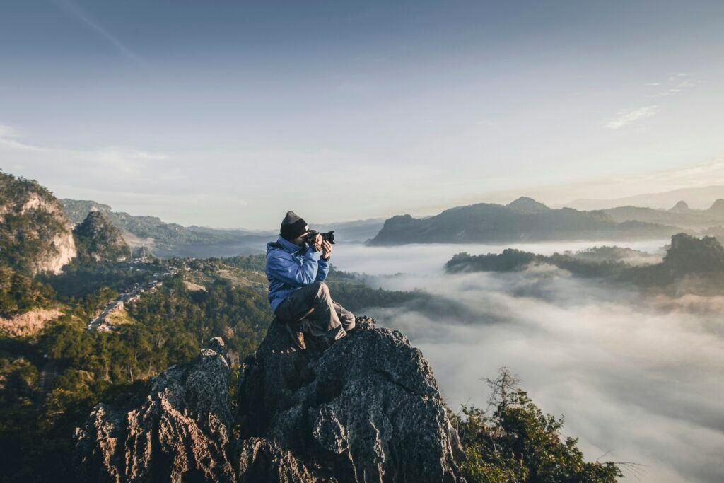man on top of mountain taking pictures man on top of mountain taking pictures