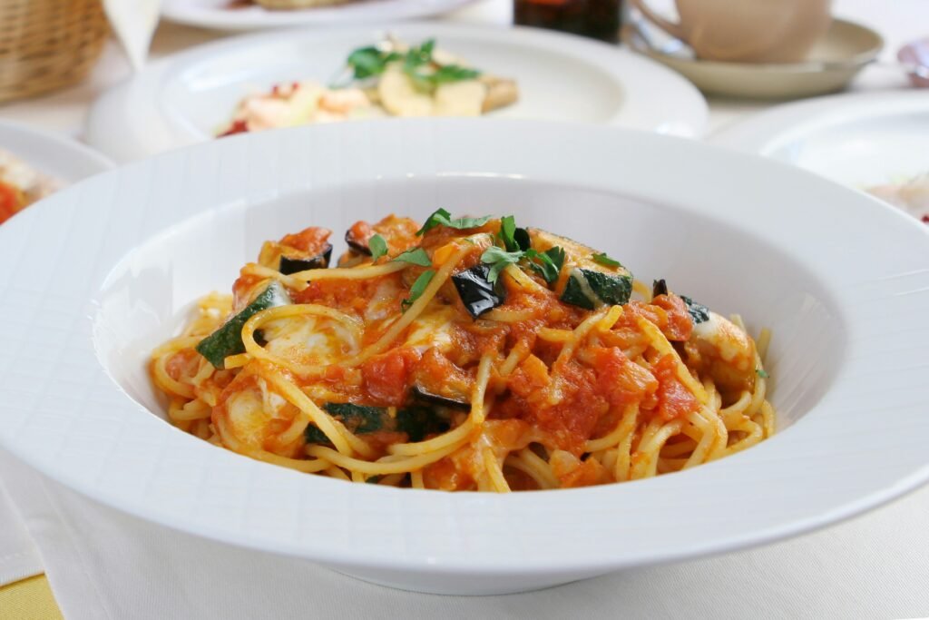 A white bowl filled with pasta and sauce