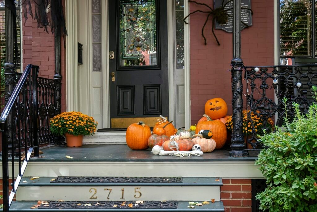 a front porch decorated for halloween with pumpkins and gourds a front porch decorated for halloween with pumpkins and gourds