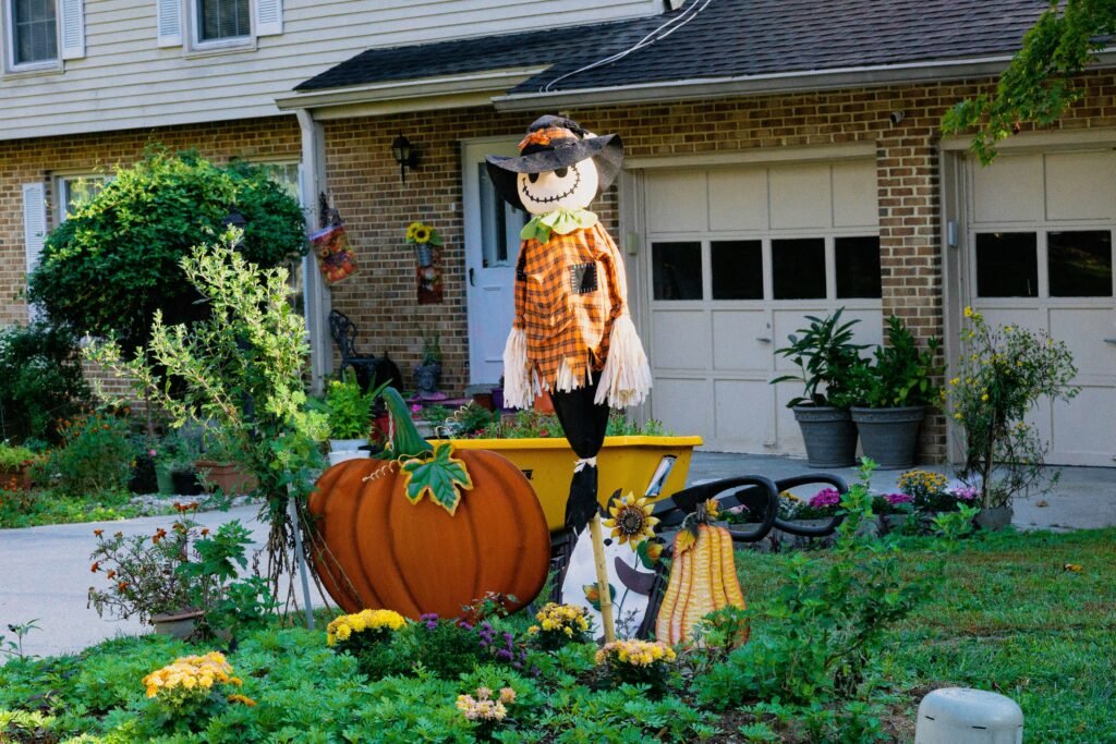 a scarecrow in a pumpkin costume in a yard a scarecrow in a pumpkin costume in a yard